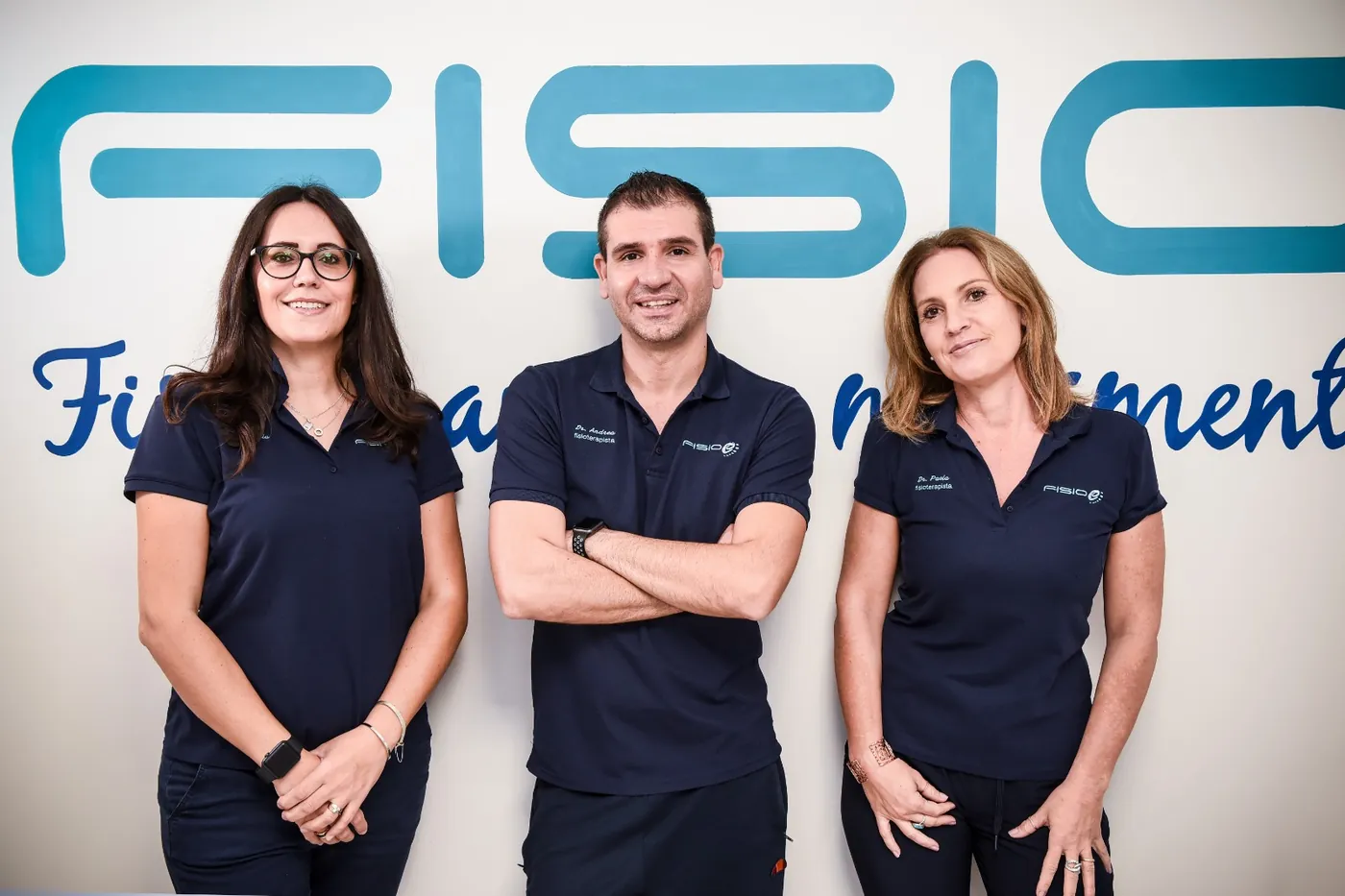 Il team dello studio Fisioe davanti al logo